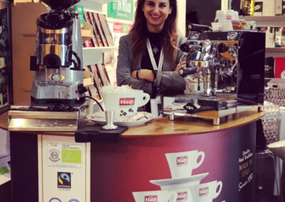 Stand di caffè italiano con barista sorridente.